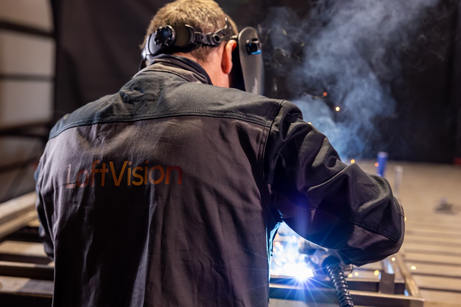 Warsztat LoftVision — spawacz pracujący przy drzwiach loftowych