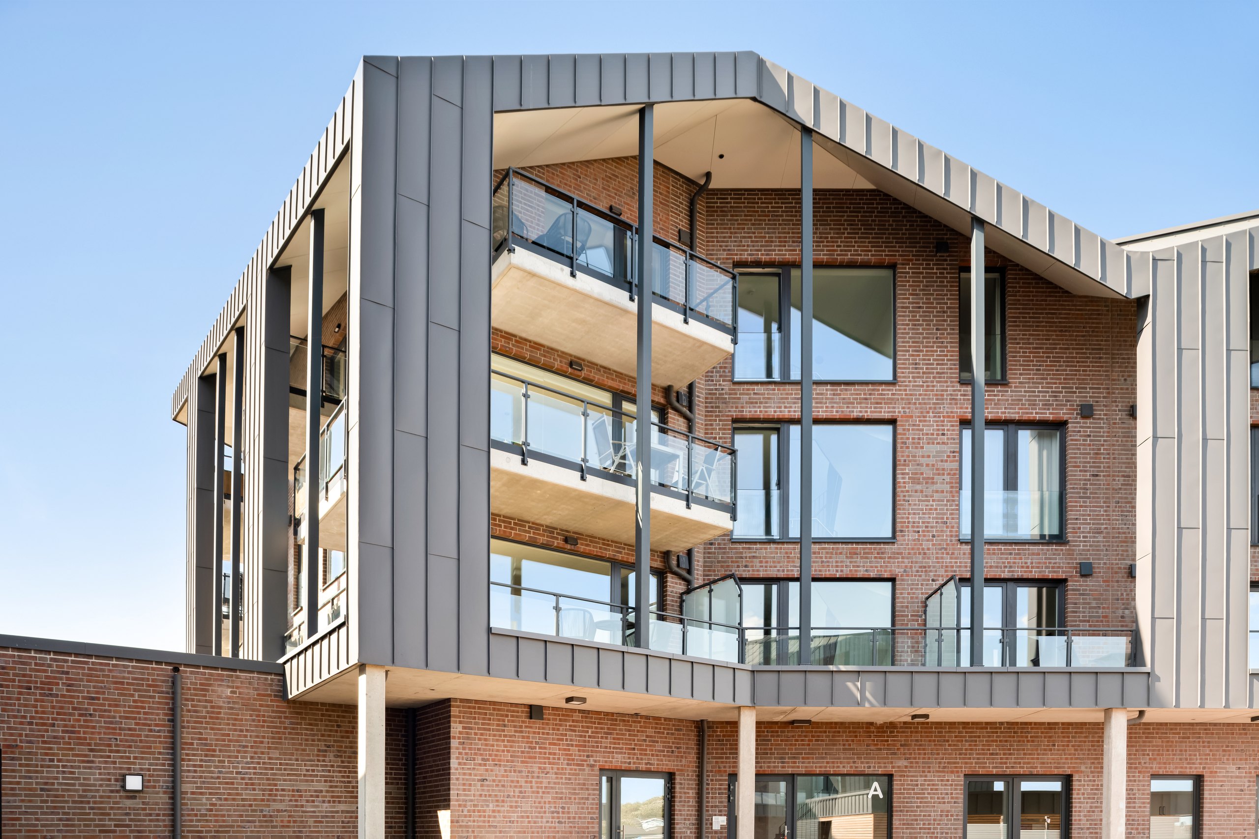 Detal architektury The View: narożnik z obramowaniem na rąbek stojący, balkonami i szklanymi balustradami