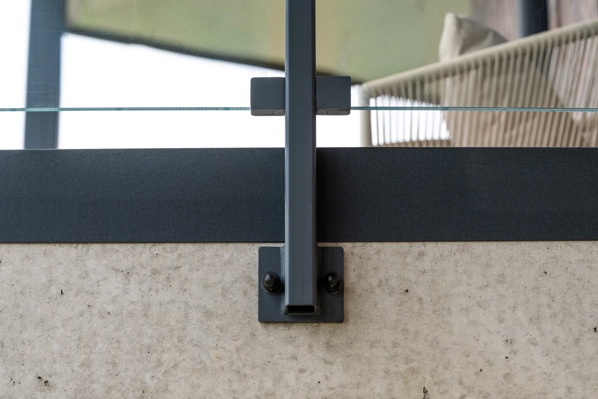Słupek balustrady z przykręcaną stopą przy betonowej krawędzi