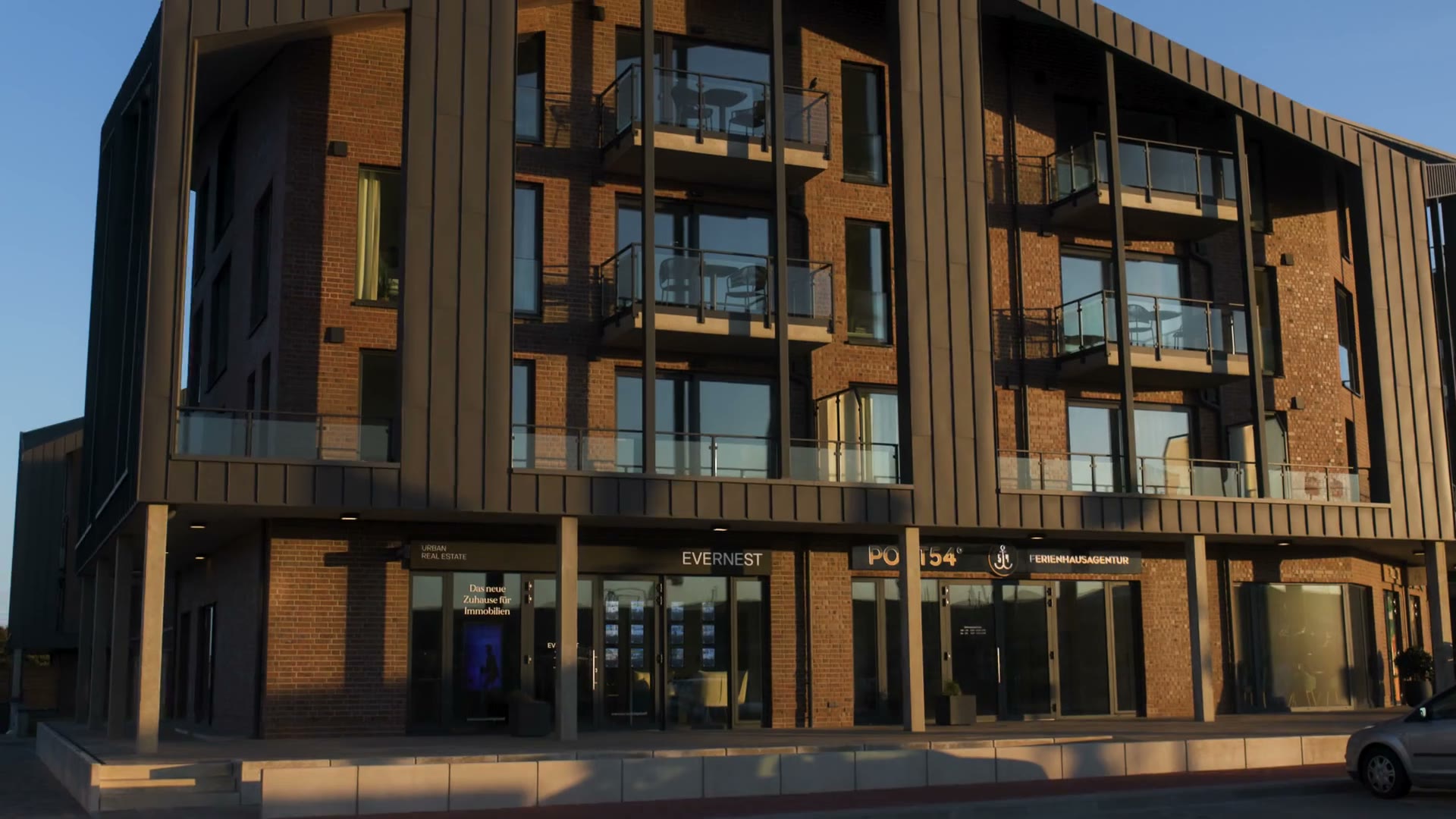 Montaż filmowy: apartamentowiec ze stalowymi balkonami, balustrada z poręczą na klatce schodowej, schody stalowe z drewnianymi stopniami, spawanie kratownicy z iskrami i zbliżenie spawania MIG w zakładzie