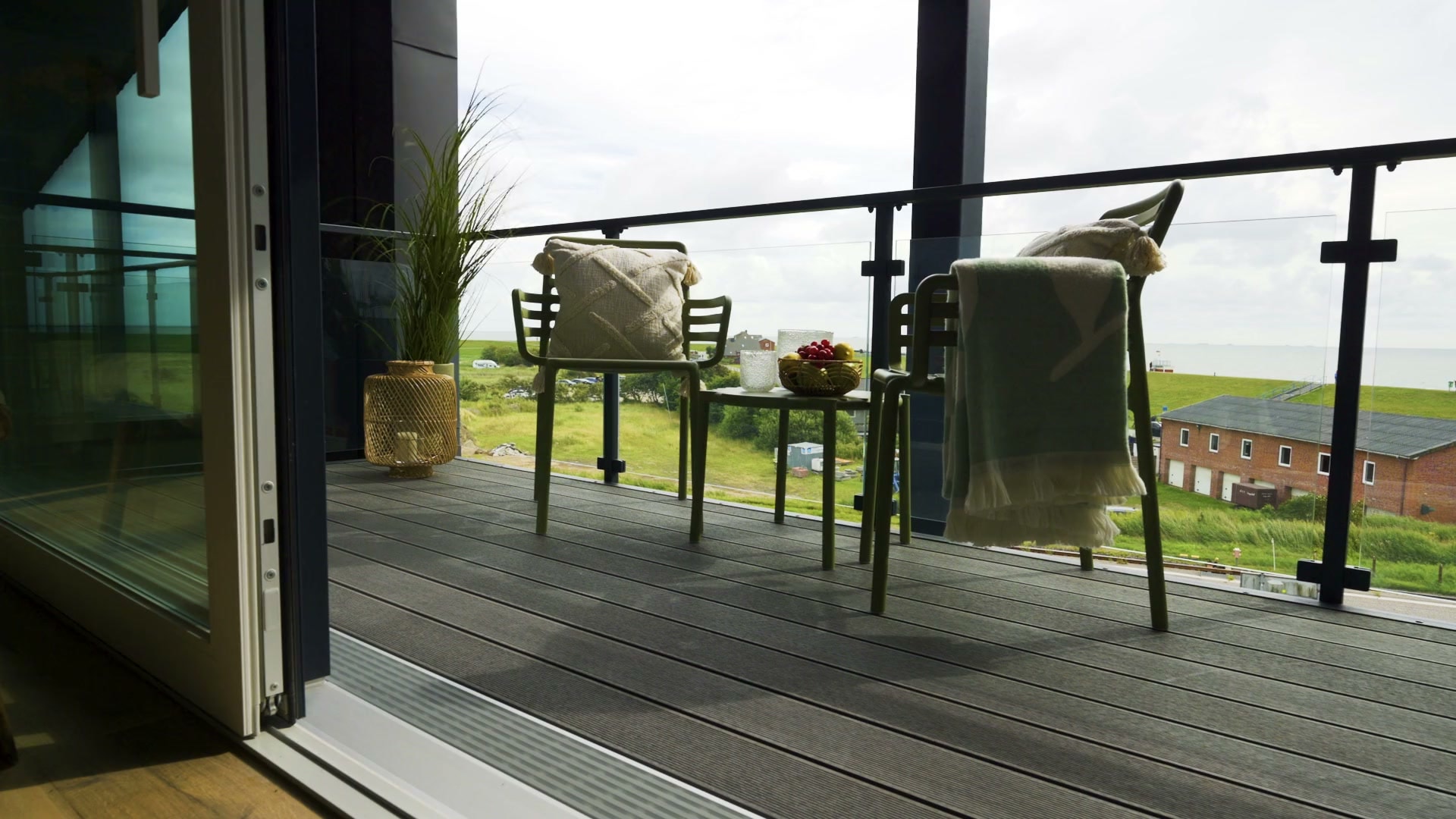 Balkon The View ze szklaną balustradą na stalowych słupkach i widokiem ponad wałem Morza Północnego